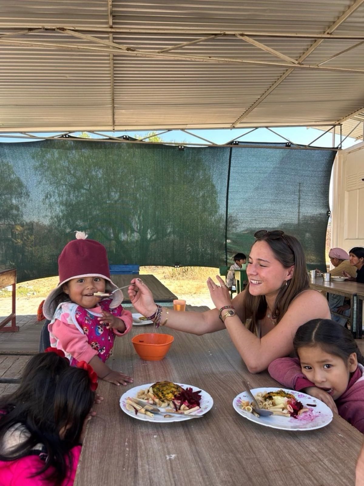 A volunteer feeds a little girl at the comedor in Cochabamba